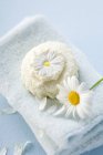 Вид крупным планом на мыло Маргариты и цветок Маргариты на полотенце — стоковое фото