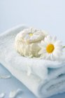 Вид крупным планом на мыло Маргариты и цветок Маргариты на полотенце — стоковое фото
