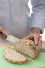 Femme tranchant le pain — Photo de stock