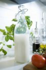Бутылка молока рядом с другими ингредиентами — стоковое фото