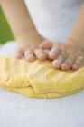 Closeup view of child hands kneading dough — Stock Photo