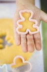 Closeup cropped view of child hand with bear-shaped dough cutter — Stock Photo