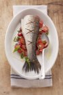Fried fish on bed of tomatoes — Stock Photo