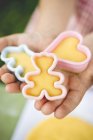 Cropped view of child holding cut-out biscuits — Stock Photo