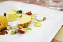 Nahaufnahme von Obst-Dessert mit Sahne und Gebäck auf Platte — Stockfoto