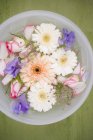 Vue de dessus des fleurs mélangées dans un bol d'eau — Photo de stock