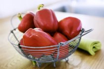 Red peppers in wire basket — Stock Photo