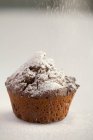Sprinkling muffin with icing sugar — Stock Photo