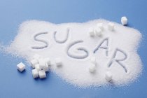 Vista elevada de la pila de azúcar con la palabra azúcar escrita en ella - foto de stock