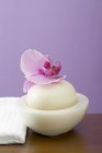 Vista close-up da orquídea no sabão na tigela ao lado da toalha branca — Fotografia de Stock