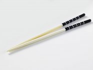 Closeup view of a pair of chopsticks on a white surface — Stock Photo