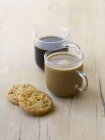 Tazas de café y galletas de vidrio - foto de stock