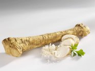 Fresh Horseradish with slices and parsley — Stock Photo