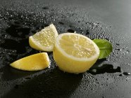 Limón fresco en rodajas con hoja - foto de stock