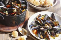 Steamed mussels on wooden table — Stock Photo