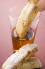 Hand dipping cantucci — Stock Photo