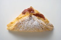 Closeup view of puff pastry with jam filling on white background — Stock Photo