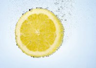 Rebanada de limón en agua - foto de stock