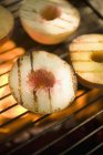 Closeup view of peaches on a barbecue grill rack — Stock Photo