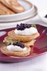 Closeup view of Blinis topped with sour cream and caviar — Stock Photo