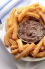 Closeup view of Churros with chocolate dipping sauce — Stock Photo