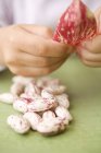 Дитячі руки очищають бобові боби — стокове фото