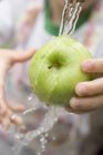 Child holding green apple — Stock Photo