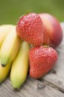 Bananas with strawberries and nectarine — Stock Photo