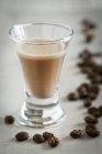 Vista close-up de licor de café e grãos de café — Fotografia de Stock