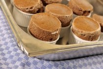Chocolate souffles on a baking tray — Stock Photo