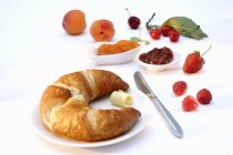 Croissant y frutas frescas para el desayuno - foto de stock