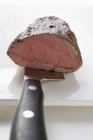Roast beef fillet on knife — Stock Photo