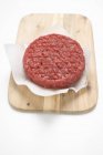 Raw burger on paper — Stock Photo