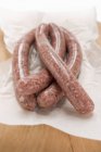 Raw sausages on paper — Stock Photo