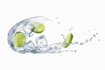Splash of water with sliced lime — стоковое фото
