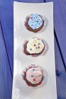 Schokolade Cupcakes mit farbiger Sahne belegt — Stockfoto