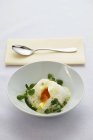 Nahaufnahme eines pochierten Eies auf Kräutercreme mit Brunnenkresse — Stockfoto