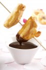 Vista de primer plano de fondue de chocolate con fruta maltratada - foto de stock