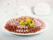 Platter with sliced ham — Stock Photo