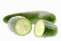Whole and halved cucumbers — Stock Photo