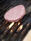 Placer le hamburger sur le support de barbecue — Photo de stock