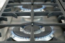 Vista de primer plano de las placas de gas encendidas de la cocina - foto de stock