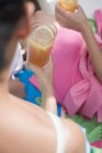 Mulheres em roupas de verão segurando copos de chá gelado — Fotografia de Stock