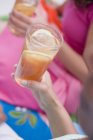 Vista cortada de mulheres segurando copos de chá gelado — Fotografia de Stock