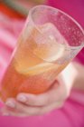 Vue rapprochée du verre de thé glacé tenu à la main — Photo de stock