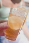 Vista ravvicinata di mano che tiene il vetro di tè freddo — Foto stock