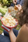 Young people with crisps and iced tea on the 4th of July — Stock Photo