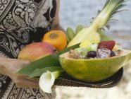 Primer plano vista recortada de la mujer sosteniendo bandeja de fruta fresca exótica - foto de stock
