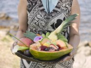 Жінка тримає лоток екзотичних фруктів — стокове фото