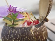 Geöffnete Kokosnuss mit Minze und Orchidee — Stockfoto